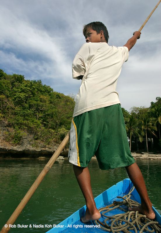 Boy steering our boat at 100 Islands, Philippines